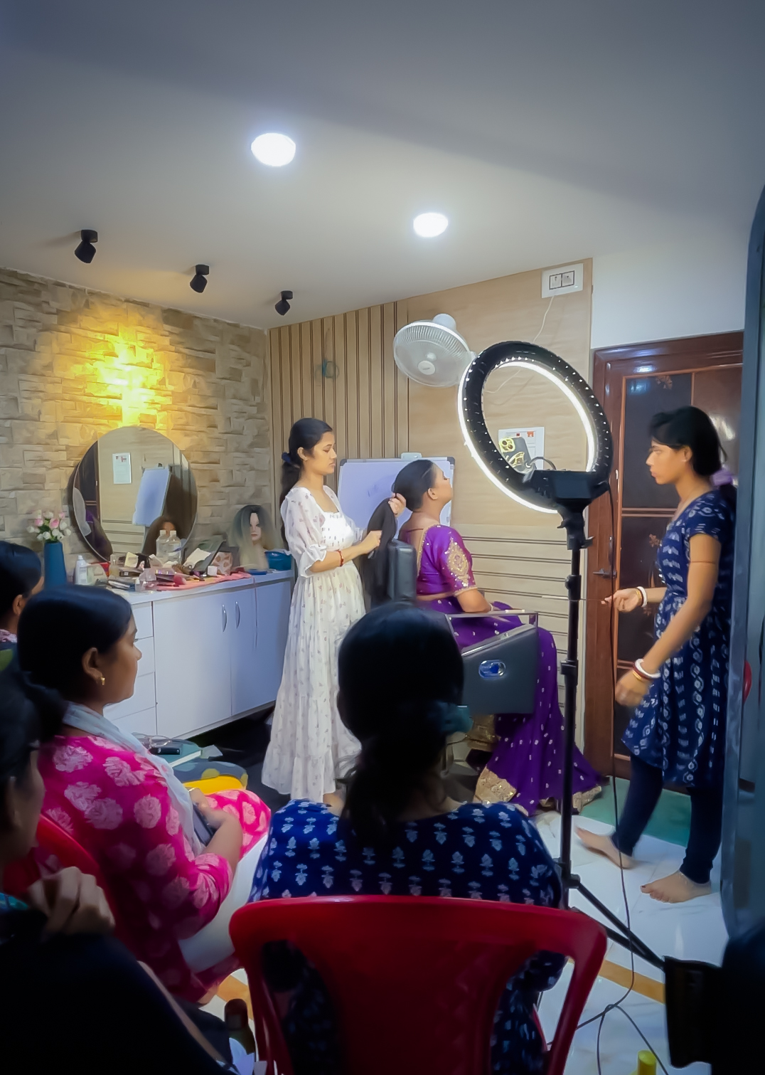 Students observing a live makeup demonstration at the Pearl Beauty Salon & Academy studio classroom