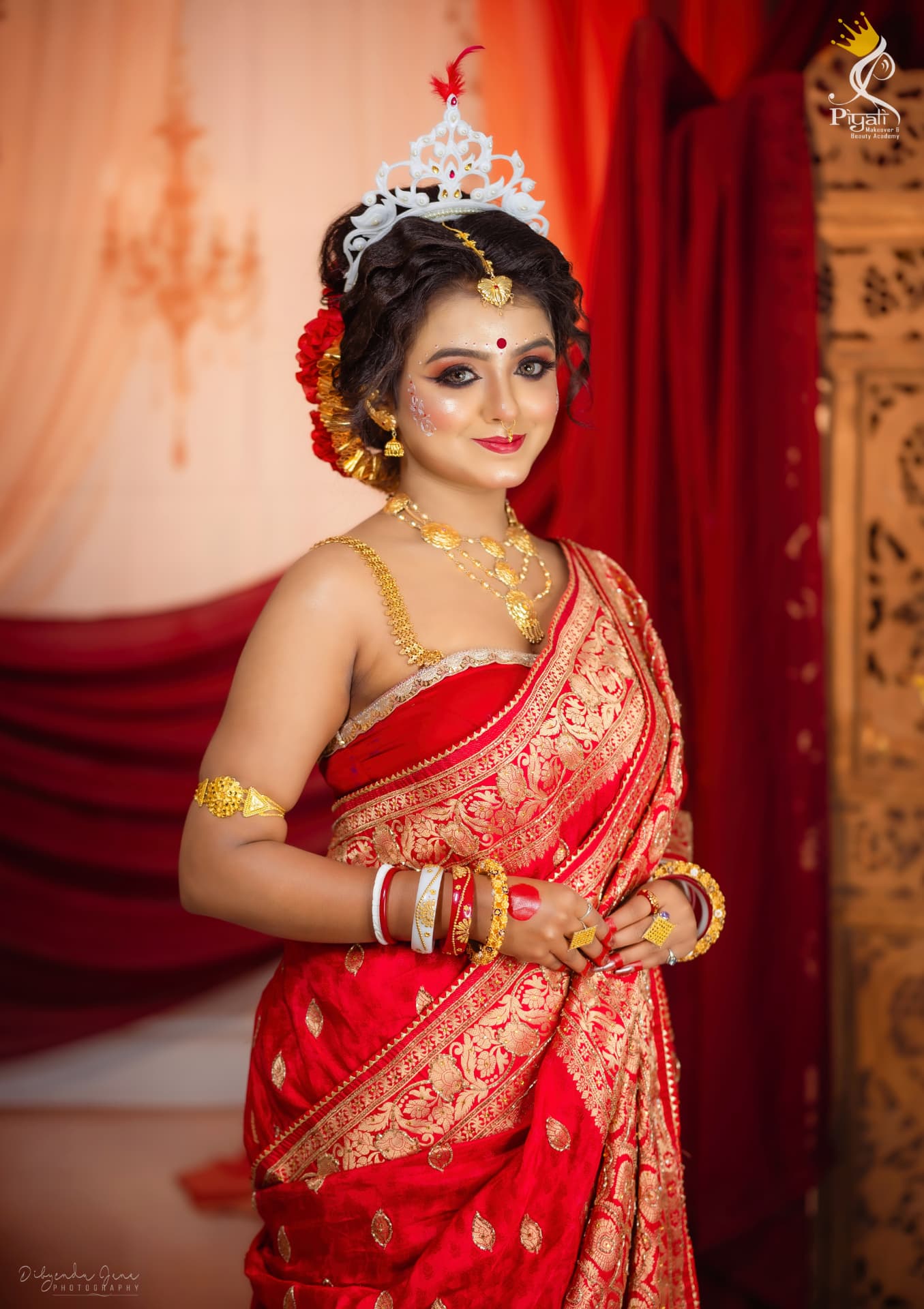 Bengali bride in a red benarasi sari and traditional white mukut with gold jewellery